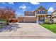 Inviting two-story home featuring a three-car garage, covered front porch, and well-maintained landscaping at 25262 E 2Nd Pl, Aurora, CO 80018