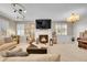 Cozy living room featuring a fireplace, elegant chandelier, and comfortable seating at 25262 E 2Nd Pl, Aurora, CO 80018