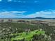 An aerial shot showcasing the lush green golf course with scenic views of mountains and clear blue skies at 7134 Kiowa Rd, Larkspur, CO 80118