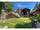 A backyard with a well-manicured artificial turf lawn and a wooden patio shaded by a pergola at 7134 Kiowa Rd, Larkspur, CO 80118