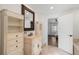 Bathroom with tile floors, white decorative vanity with mirror, and view of bedroom at 7134 Kiowa Rd, Larkspur, CO 80118