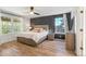 Well-lit bedroom with hardwood floors, black accent wall, and windows with backyard views at 7134 Kiowa Rd, Larkspur, CO 80118