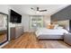Well-lit bedroom with hardwood floors, black accent wall, and windows with backyard views at 7134 Kiowa Rd, Larkspur, CO 80118