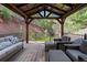 A covered wooden deck with comfortable furniture and beautiful views of the surrounding landscape at 7134 Kiowa Rd, Larkspur, CO 80118