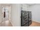 Well-equipped laundry area featuring modern washer and dryer units with shelving and ample storage space at 7134 Kiowa Rd, Larkspur, CO 80118