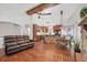 Spacious open-concept living room with hardwood floors and a stone fireplace leading to the kitchen and dining area at 7134 Kiowa Rd, Larkspur, CO 80118