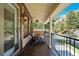 Inviting covered front porch with wooden floors, railings, and mountain views in the background at 7134 Kiowa Rd, Larkspur, CO 80118