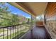 Covered back porch with wooden floors, railings, and scenic landscape views at 7134 Kiowa Rd, Larkspur, CO 80118