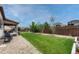 Manicured backyard with green grass, a wood fence, rock features, and shade trees at 22583 E Union Cir, Aurora, CO 80015