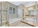 A bright bathroom featuring a soaking tub, tiled shower, and double sink vanity with modern fixtures at 22583 E Union Cir, Aurora, CO 80015