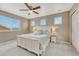 Bright bedroom featuring a ceiling fan, neutral walls, large window, and a cozy white bed with a white headboard at 22583 E Union Cir, Aurora, CO 80015