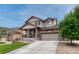 Attractive two-story house showcases a covered porch, stone detailing, a driveway, and a low-maintenance landscaped yard at 22583 E Union Cir, Aurora, CO 80015