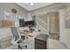 Stylish home office featuring a modern desk, comfortable seating, and a glimpse of a staircase in a well-lit space at 22583 E Union Cir, Aurora, CO 80015