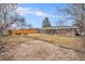 A spacious backyard with a grassy lawn, gravel area, and a wooden fence at 3149 Wheeling St, Aurora, CO 80011