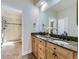 Bathroom featuring double sinks, granite countertops, wood cabinets and a glass enclosed shower at 8390 E Summit Rd, Parker, CO 80138