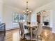 Dining room with hardwood floors, chandelier, large windows overlooking the forest, and an arched doorway at 8390 E Summit Rd, Parker, CO 80138