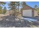 Exterior of detached two-car garage with stone accents, and view of the house in the background at 8390 E Summit Rd, Parker, CO 80138