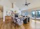 Bright living room featuring a stone fireplace, hardwood floors, large windows, and access to a balcony at 8390 E Summit Rd, Parker, CO 80138