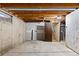 Unfinished basement with wooden beams, concrete floor, and a door at 446 Dione Pl, Lone Tree, CO 80124