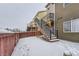 Backyard with stairs to deck and snowy ground at 1405 Willow Oak Rd, Castle Rock, CO 80104