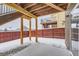 Backyard with wood deck, fenced area, and snowy ground at 1405 Willow Oak Rd, Castle Rock, CO 80104