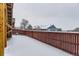 Snowy backyard with a wooden fence and a view of neighboring houses at 1405 Willow Oak Rd, Castle Rock, CO 80104