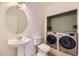 Bathroom with pedestal sink, toilet, and laundry closet at 1405 Willow Oak Rd, Castle Rock, CO 80104