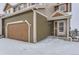 Exterior view of a two-story townhome with snow on the ground and an attached garage at 1405 Willow Oak Rd, Castle Rock, CO 80104