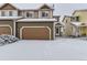 Two-story townhome with attached garage, snow covered at 1405 Willow Oak Rd, Castle Rock, CO 80104