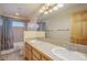 Well-lit bathroom with a double vanity, tiled floors, and a shower-tub combination at 31755 Ponderosa Way, Evergreen, CO 80439