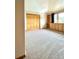 Cozy bedroom with built-in wood shelves, neutral walls, and carpeting with a large closet at 31755 Ponderosa Way, Evergreen, CO 80439