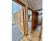 Bedroom entryway featuring wood flooring and doors leading to a bedroom with a window and a bathroom at 31755 Ponderosa Way, Evergreen, CO 80439