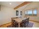 Bright dining room with a wooden table set under a beamed ceiling, complemented by a large window with scenic views at 31755 Ponderosa Way, Evergreen, CO 80439