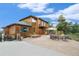 Large home exterior with a spacious backyard and patio area at 31755 Ponderosa Way, Evergreen, CO 80439