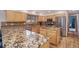 Beautiful kitchen with wooden cabinets, stainless steel appliances and gorgeous granite countertops on an island at 31755 Ponderosa Way, Evergreen, CO 80439