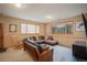 Cozy living room with sectional sofa, rocking chair and large windows at 31755 Ponderosa Way, Evergreen, CO 80439