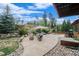 Back patio featuring a fire pit, landscaping and built-in seating at 31755 Ponderosa Way, Evergreen, CO 80439