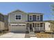 Charming two-story home featuring a covered porch, two-car garage, and nicely landscaped front yard at 21996 E 39Th Pl, Aurora, CO 80019