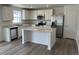 Bright kitchen featuring white cabinets, stainless steel appliances, an island with countertops, and wood flooring at 21996 E 39Th Pl, Aurora, CO 80019