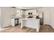 Stylish kitchen featuring white cabinets, stainless steel appliances, quartz countertops, and an island at 21996 E 39Th Pl, Aurora, CO 80019