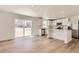 Open kitchen and living area featuring white cabinets, stainless appliances, quartz countertops and sliding glass door at 21996 E 39Th Pl, Aurora, CO 80019
