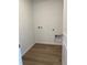 Bright laundry room featuring wood-look floors and modern utility connections at 21996 E 39Th Pl, Aurora, CO 80019