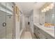 Hallway with glass door shower and double vanity with quartz countertops in primary bathroom at 2576 Villageview Ln, Castle Rock, CO 80104