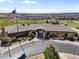 Aerial view of a Crystal Valley clubhouse featuring manicured landscaping and an American flag at 2576 Villageview Ln, Castle Rock, CO 80104