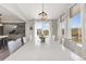 Bright dining room with a large table, white chairs, modern chandelier, and big windows with sheer curtains at 2576 Villageview Ln, Castle Rock, CO 80104