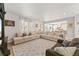 Open-concept living room featuring a large sectional sofa, decorative pillows, and an open view to the kitchen at 2576 Villageview Ln, Castle Rock, CO 80104