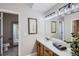 Bathroom with modern vanity, white countertop, framed mirrors, and updated lighting at 6845 S Webster St # G, Littleton, CO 80128