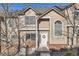 Charming townhome featuring beige siding, brick accents, and a welcoming front door with festive wreath at 6845 S Webster St # G, Littleton, CO 80128