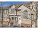 Charming townhome featuring beige siding, brick accents, and a welcoming front door with festive wreath at 6845 S Webster St # G, Littleton, CO 80128