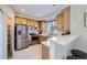 Bright kitchen featuring stainless steel appliances, wooden cabinets, and breakfast bar seating at 6845 S Webster St # G, Littleton, CO 80128